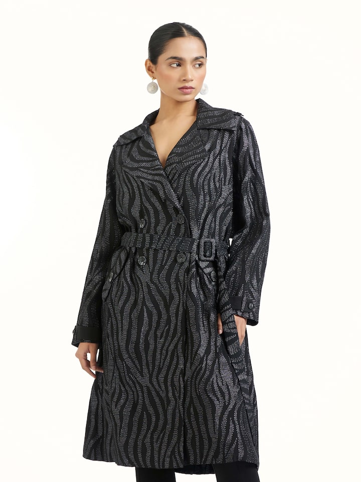 Angled view of black aari hand embroidered trenchcoat emphasizing handcrafted aari work