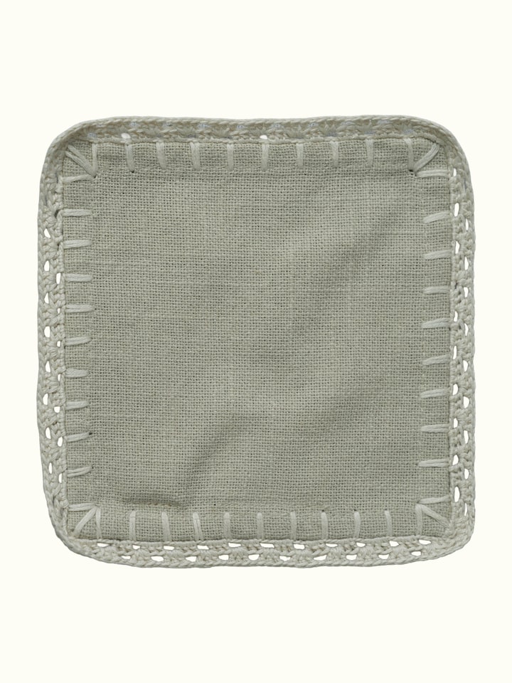 Detail view of Nityam Beige Cotton Slub Crochet Coasters Set Of 6 highlighting the fabric texture and embroidery detail