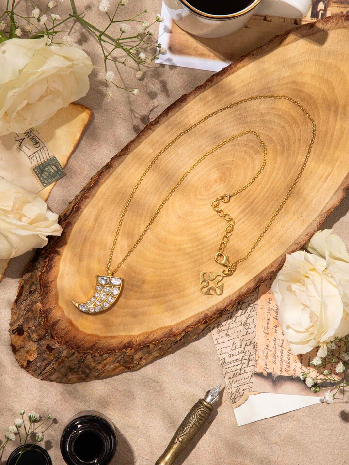 Lifestyle shot showcasing the pendant and chain styled on the neckline for an elegant look