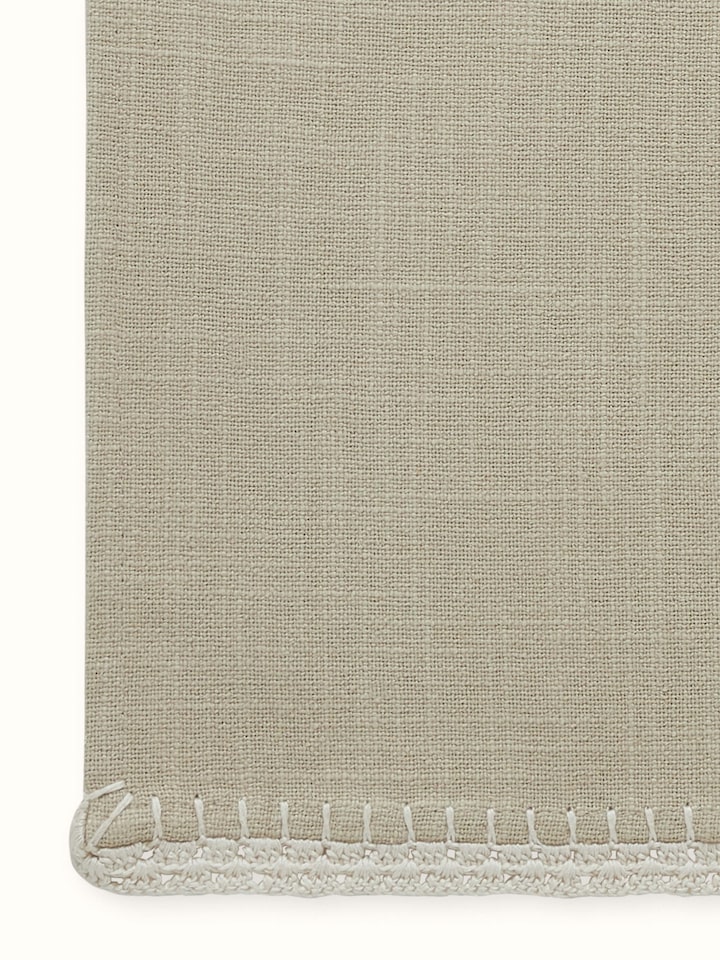 Detail view of Nityam Beige Cotton Slub Crochet Table Runner highlighting the fabric texture and embroidery detail