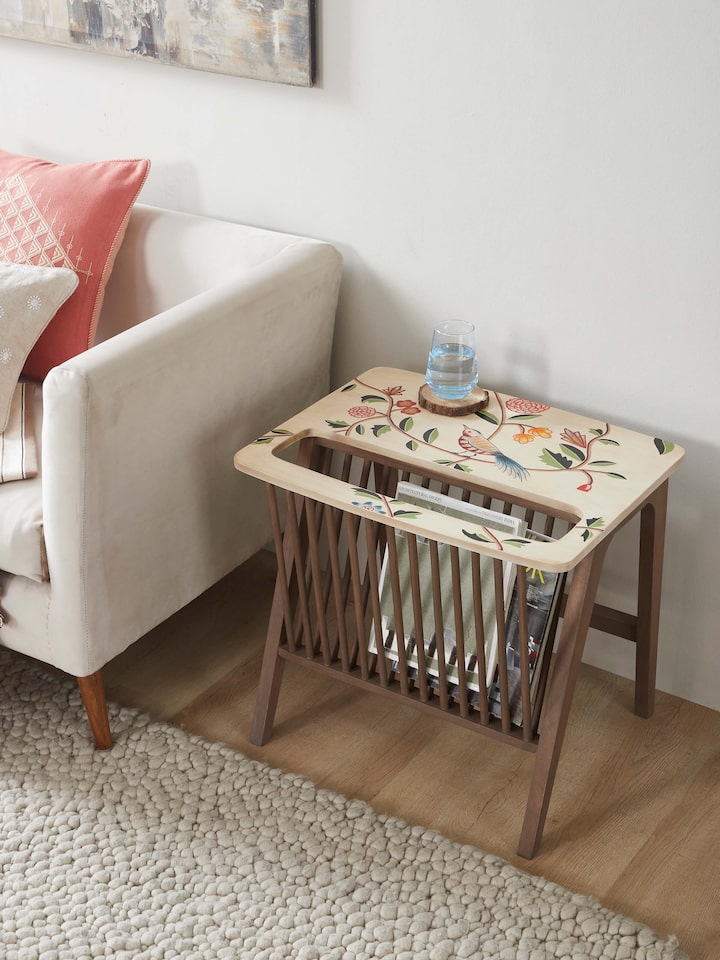 Side view of the mango wood magazine rack featuring miniature painting, highlighting its craftsmanship and storage capacity.