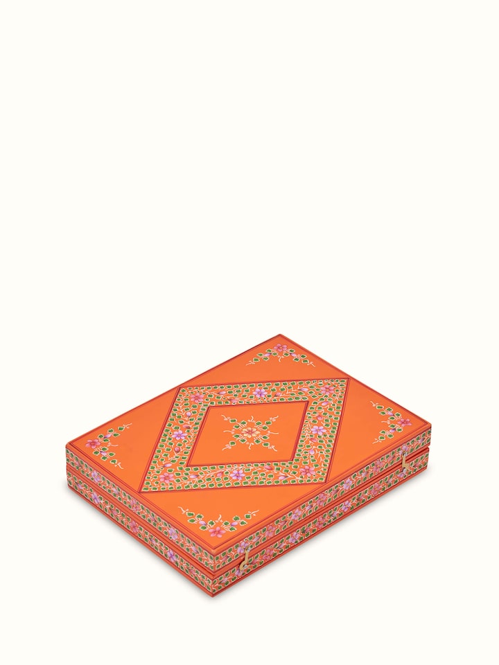 Angled view of Ganjifa cedar wood backgammon in orange highlighting the detailed patterns and cedar wood finish