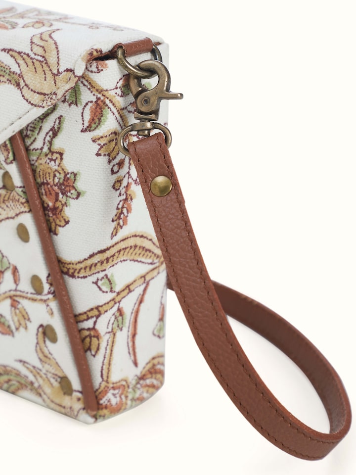 Back view of mustard leather and textile sling bag showing zipper and strap