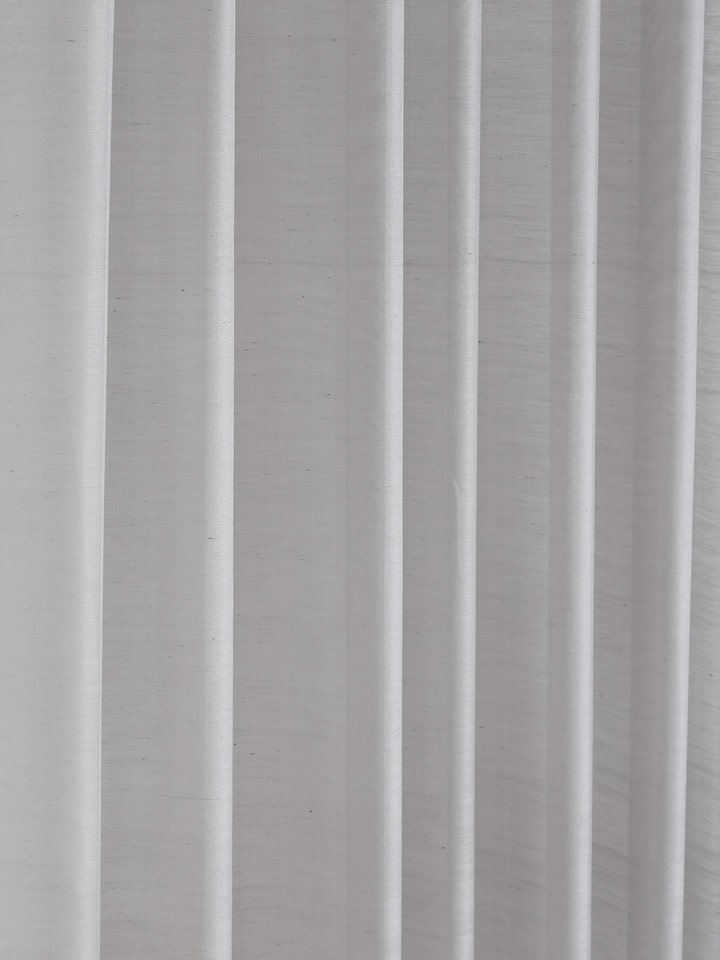 A side shot of the nine-foot Maheshwari handloom sheer curtain in grey stripe pattern, showing the transparency and soft fall of the fabric.