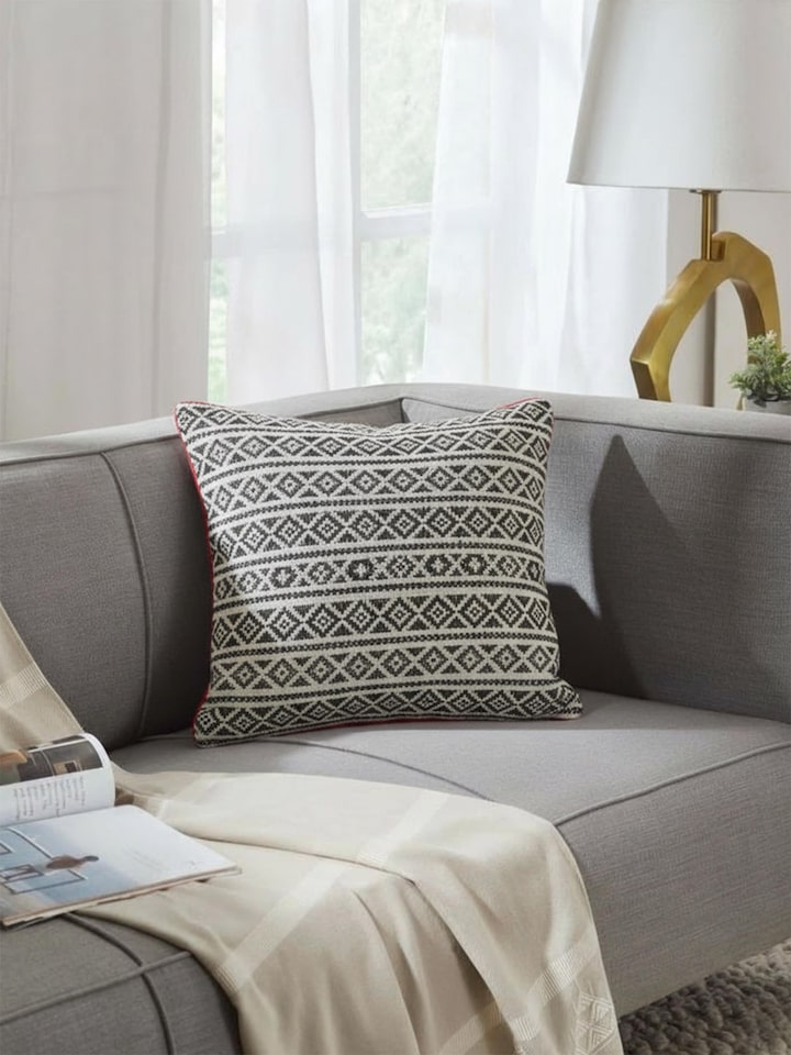 Riten black Kantha embroidered cushion cover styled on sofa