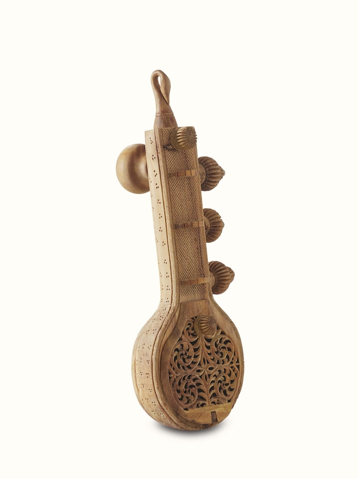 Side view of carved sandalwood Vandana Veena sculpture with detailed artwork