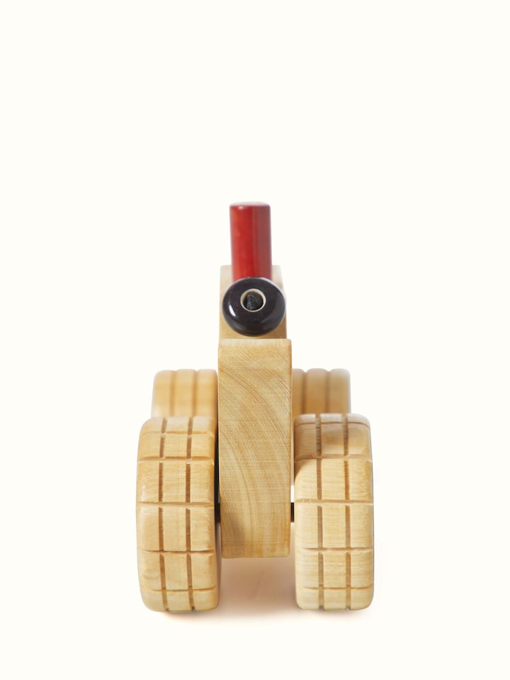 Rear view of white Channapatna ivory wood tractor toy showing the back design
