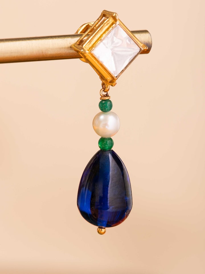 Detail shot of Dank Polki earrings showcasing uncut stones and polished gold base.