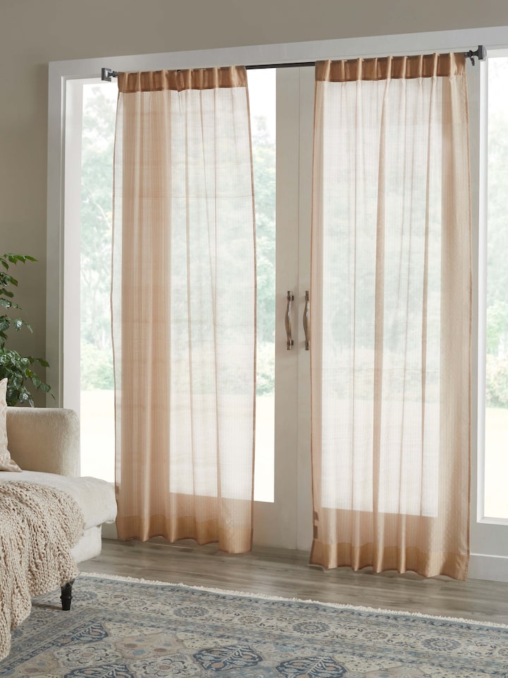Living room setup featuring beige Maheshwari handloom sheer curtain with subtle metallic stripes.