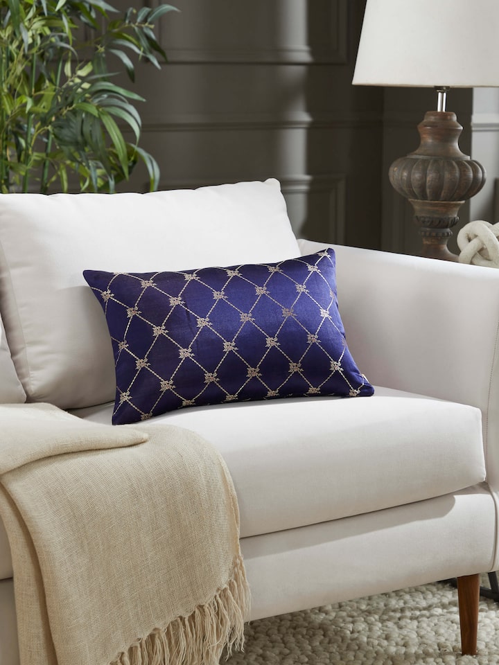 Lifestyle view of Awadh Navy Blue Banarasi Handloom Silk Lumbar Cushion Cover placed on a sofa, showcasing its elegant decor appeal.