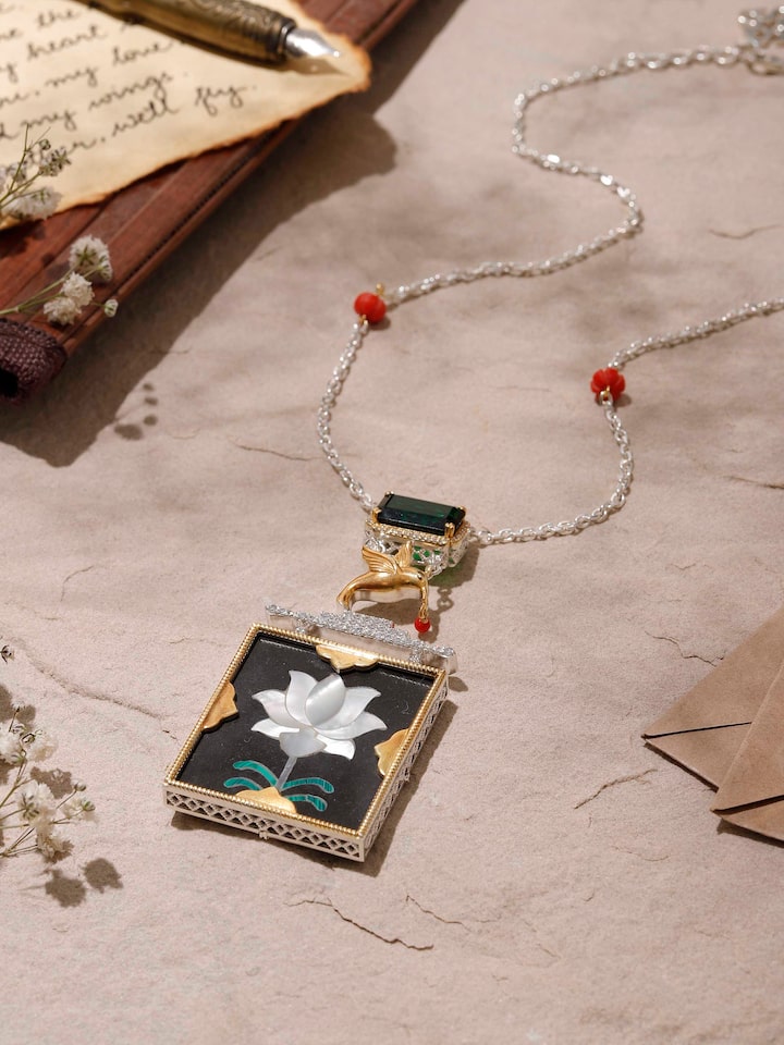 Close-up showing ornate carvings and texture on the silver pendant surface