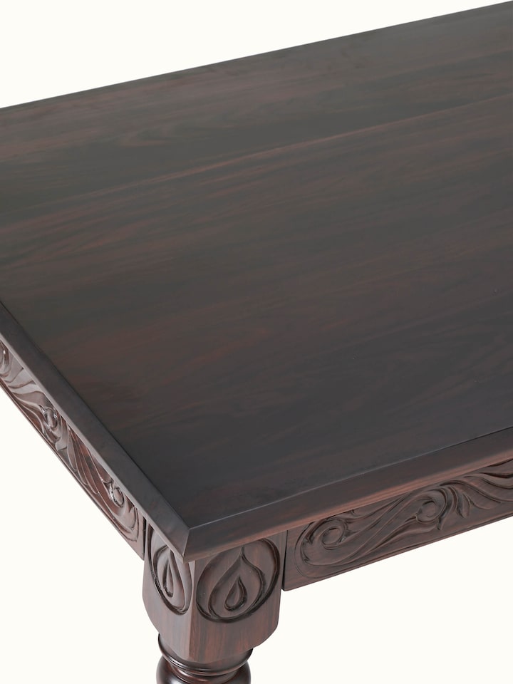 Close-up of carved rosewood 6-seater dining table surface, focusing on the detailed carvings and polished finish