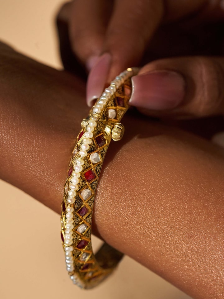 Side view of 18 karat gold bangle emphasizing smooth finish and gold quality