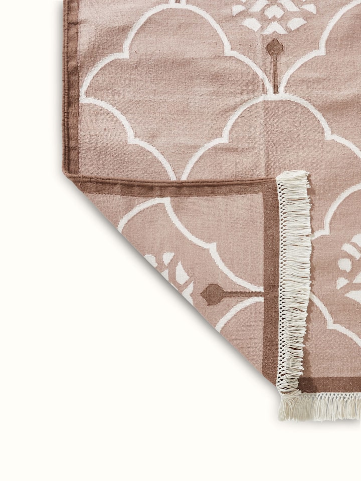Back Side view of Stylised floral beige lawan cotton panja dhurrie highlighting its traditional design