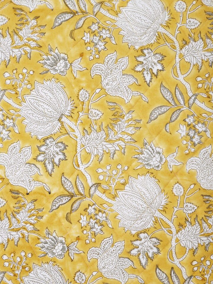 Detail shot highlighting Sanganeri floral hand block printing on yellow euro shams.