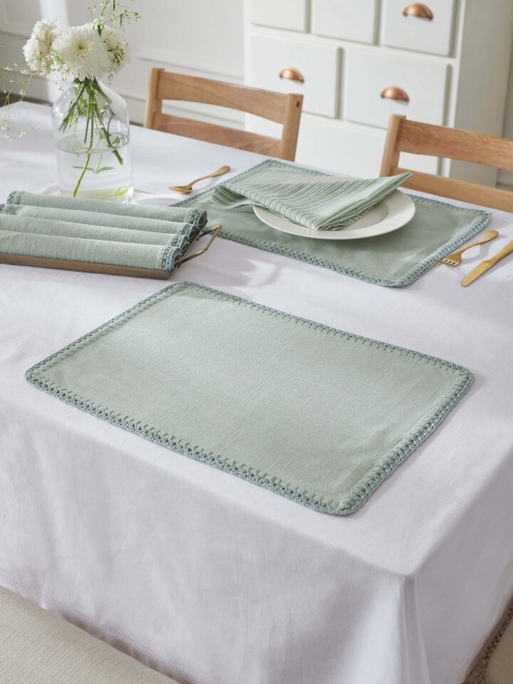 Styled view of Nityam Light Green Cotton Slub Crochet Table Mat (6 Pcs) styled on a table or bed setting