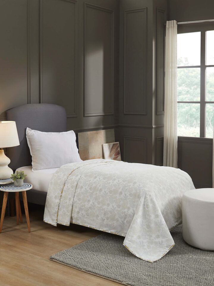 Lifestyle image of Sanganeri hand block printed dohar on a bed, emphasizing artisanal comfort.