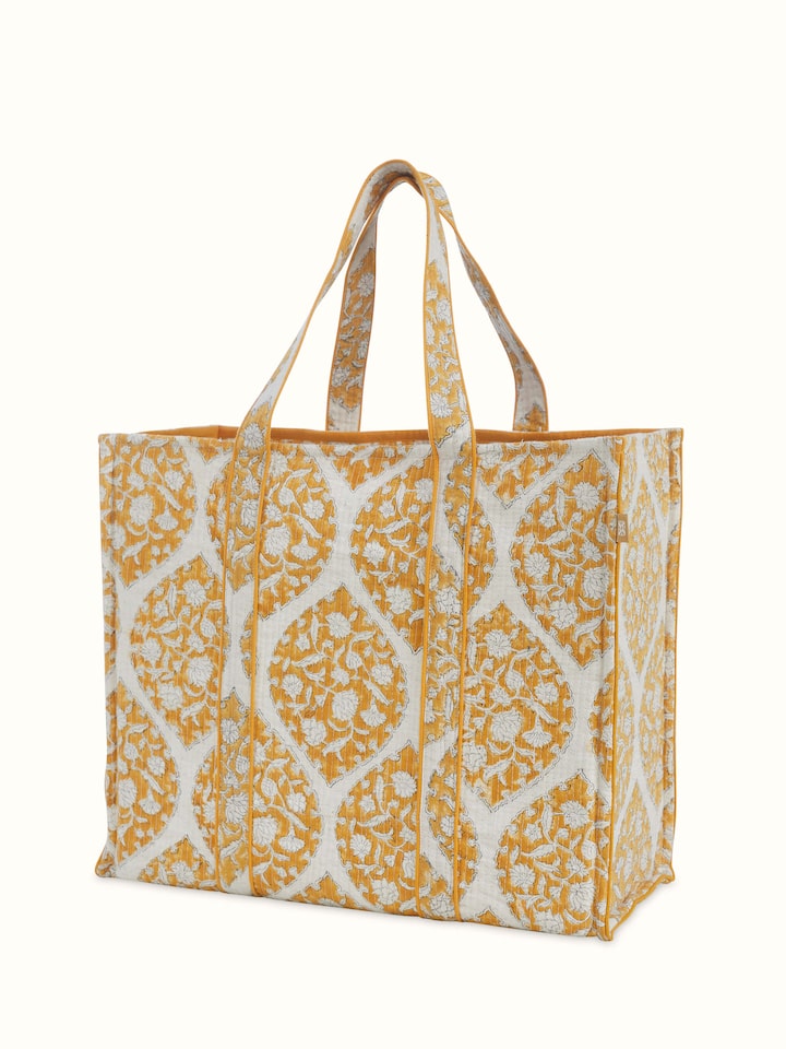 Angled view of Yellow Handblock Printed Quilted Tote Bag revealing the depth of its color and intricate pattern