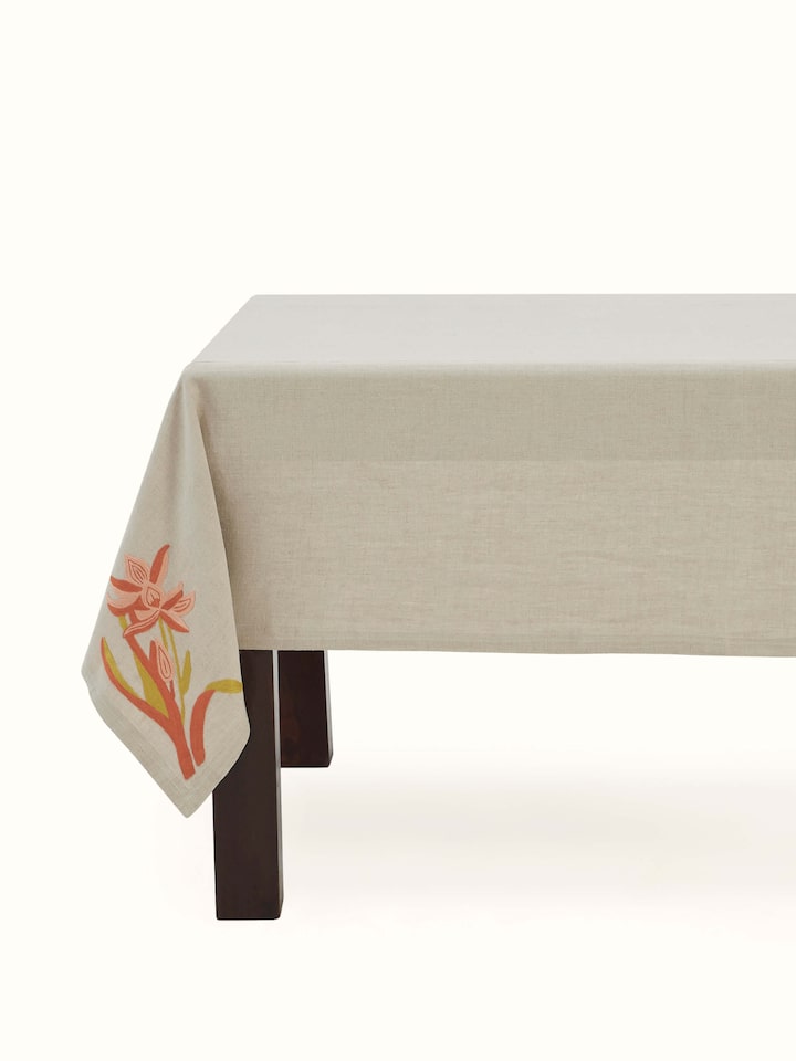 Angled close-up showing intricate floral chain stitch embroidery on beige linen fabric