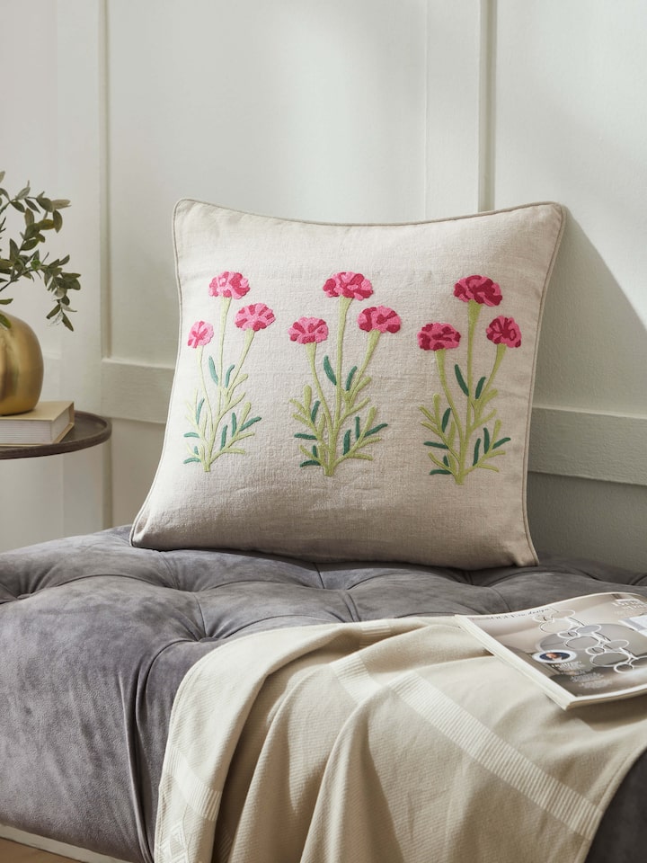 Lifestyle shot: Magenta embroidered cushion styled in a classic setting, highlighting Kashmiri craftsmanship.