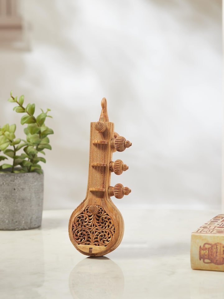Side view of carved sandalwood Vandana Veena sculpture highlighting detailed craftsmanship