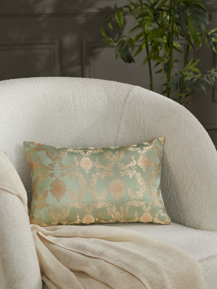 Lifestyle shot: Styled cushion with pista green jaal design adding elegance to a classic sofa setup.