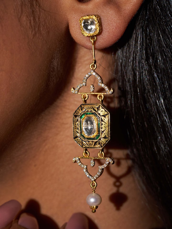 Side view emphasizing the earrings’ drop style and polish