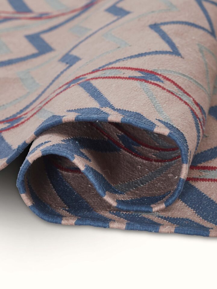 Close-up view of Geo chevron gradation blue beige lawan cotton panja dhurrie focusing on the fabric details and gradient.