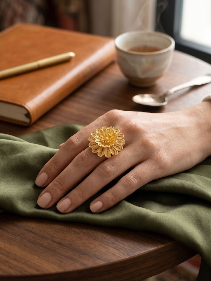 Silver Smithing Ring worn on the hand resting on a wooden desk