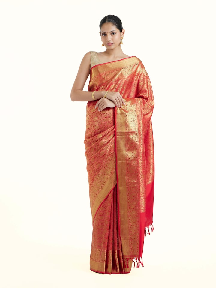 Front view of pink silk Kancheepuram saree showcasing rich zari woven motifs