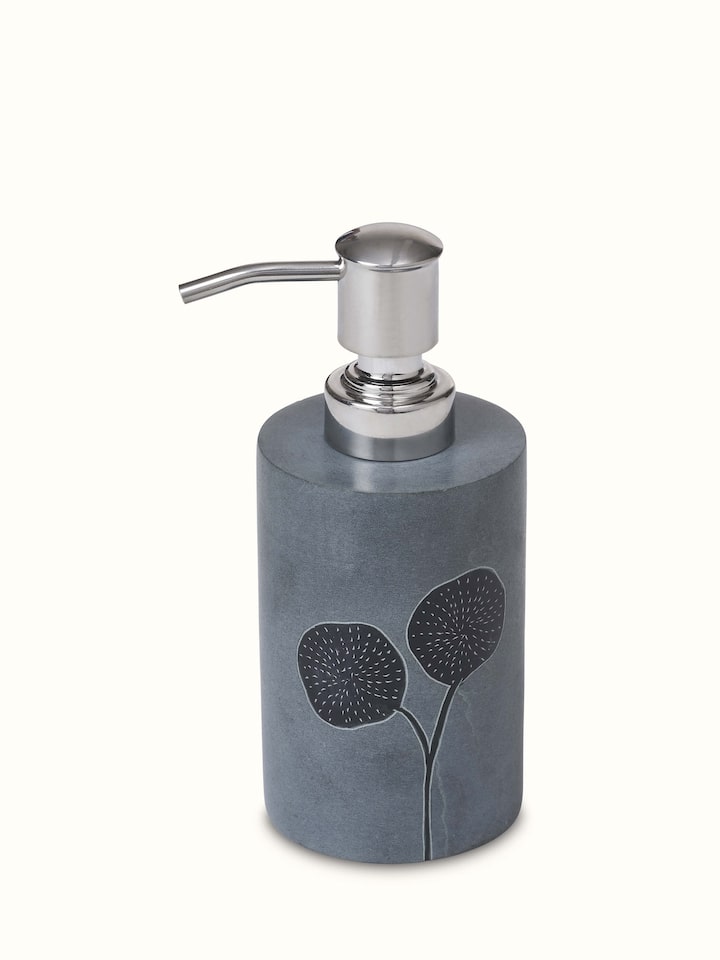 Close-up of carved stone soap dispenser revealing the elegant curves and artistic detail of the design.