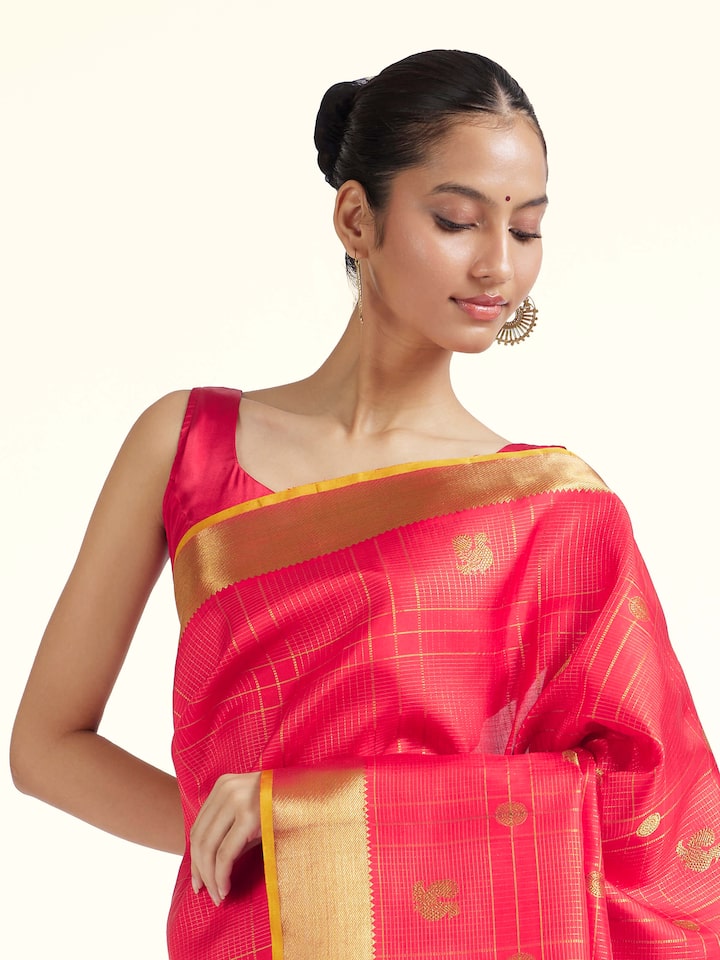 Angled view of red silk Kancheepuram saree highlighting traditional weave and sheen