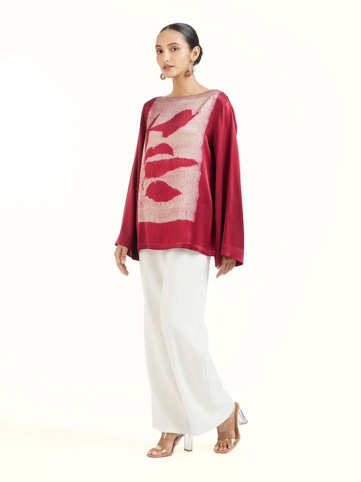 Side view of red satin Shibori top highlighting relaxed fit and drape