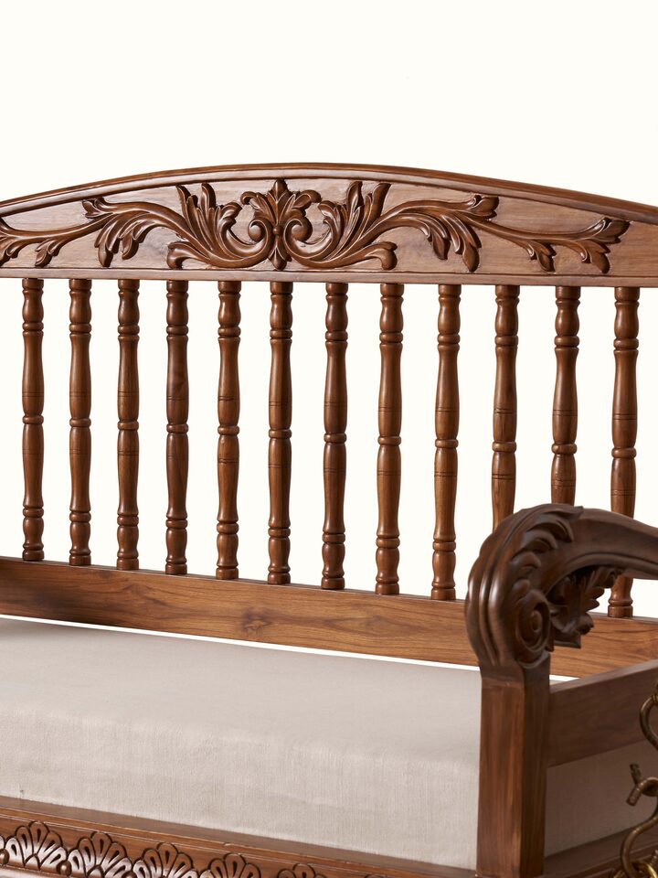 Angled view of the upholstered Sheesham wood 2-seater swing, emphasizing its swing mechanism and rich upholstery