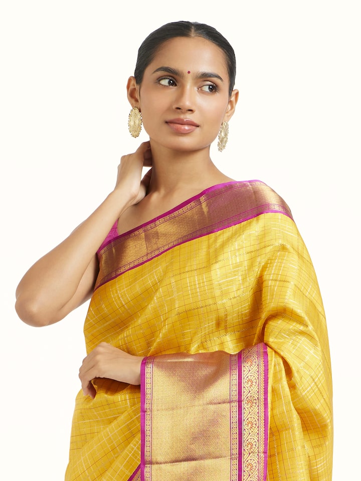 Angled view of yellow silk Kancheepuram saree highlighting lustrous weave