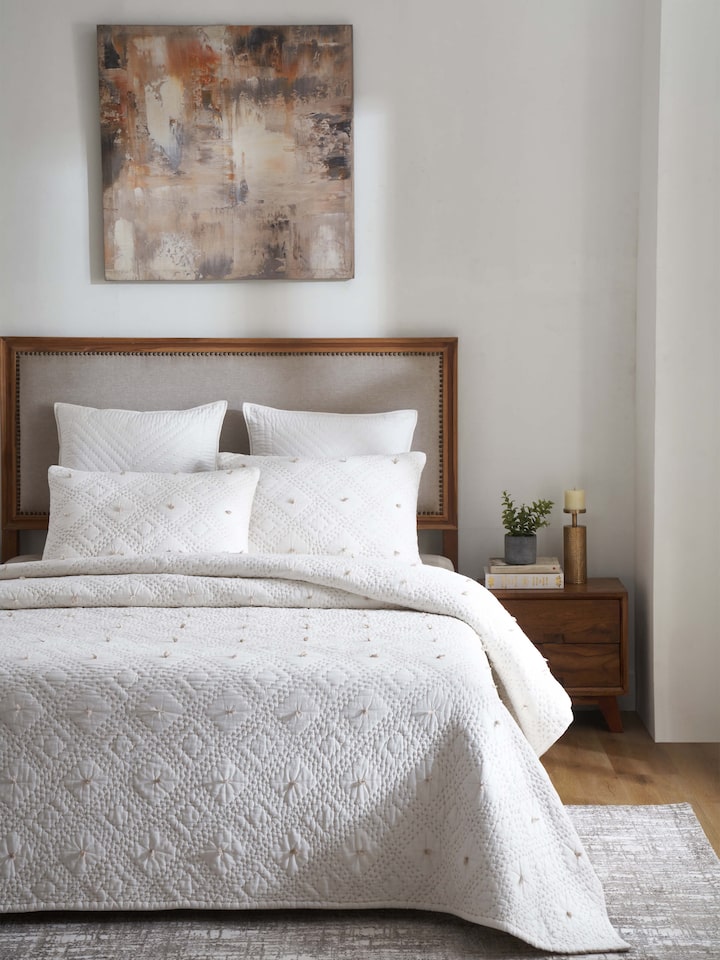 Close-up of Nihar ivory diamond geo cotton razai embroidered double bedspread set (3 pcs) highlighting the intricate embroidery and diamond pattern.