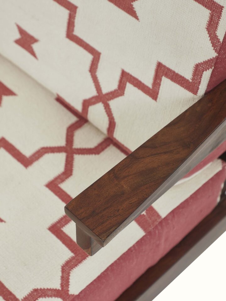 Detailed side shot of handloom dhurrie fabric and Sheesham wood frame – luxury Indian armchair design