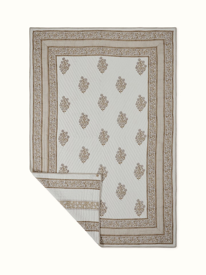 Close-up of block printed buta motifs on beige cotton double quilt from Saha collection
