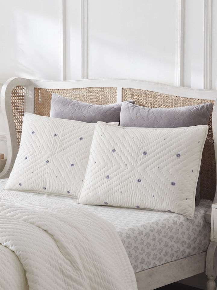 Lifestyle image showing Kalpanama Ivory Buti Cotton Pillow Shams styled on a bed