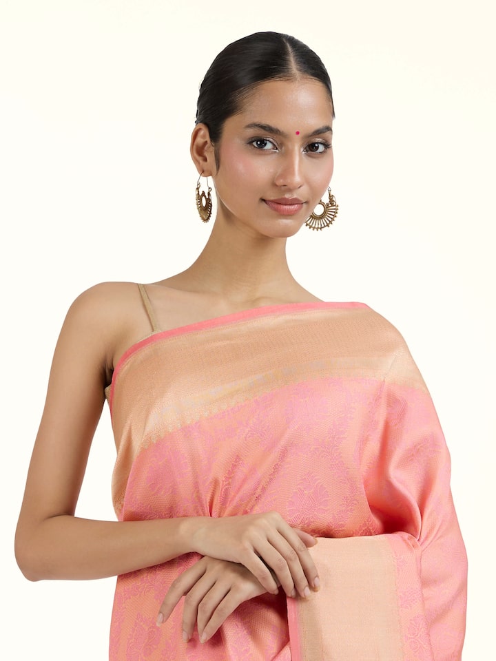 Angled view of pink silk Banarasi saree emphasizing elegant pallu detailing