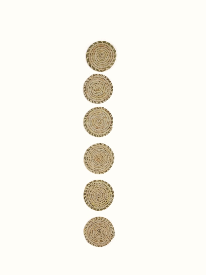 Detail shot of Amodini light green round Sabai grass coasters highlighting natural fibre texture and handwoven pattern.