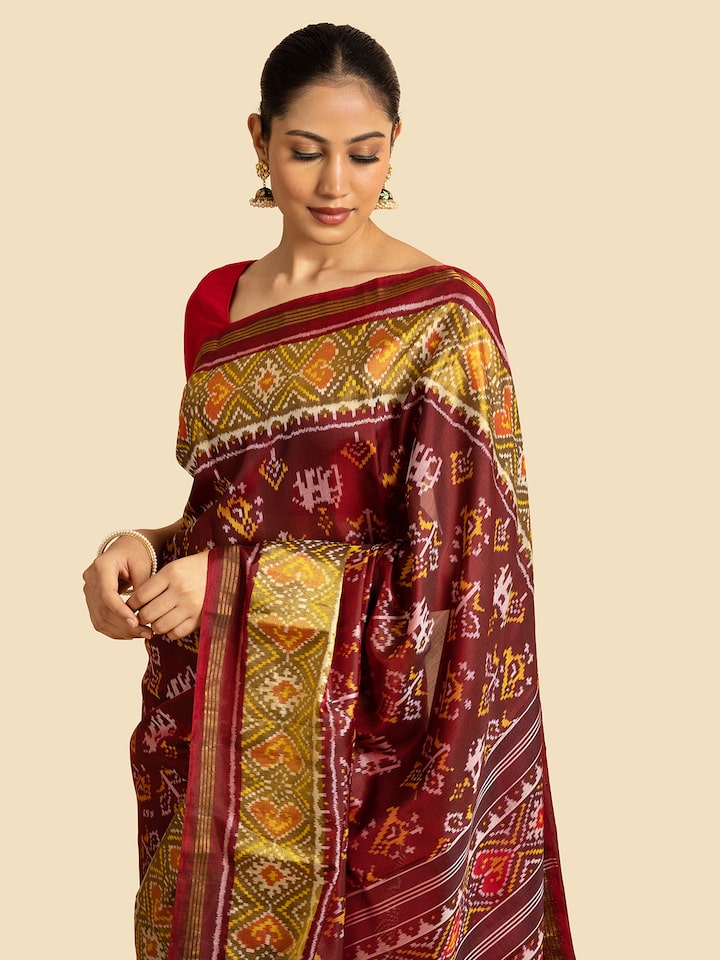 Close-up of red silk patola saree highlighting the vibrant color and traditional design elements