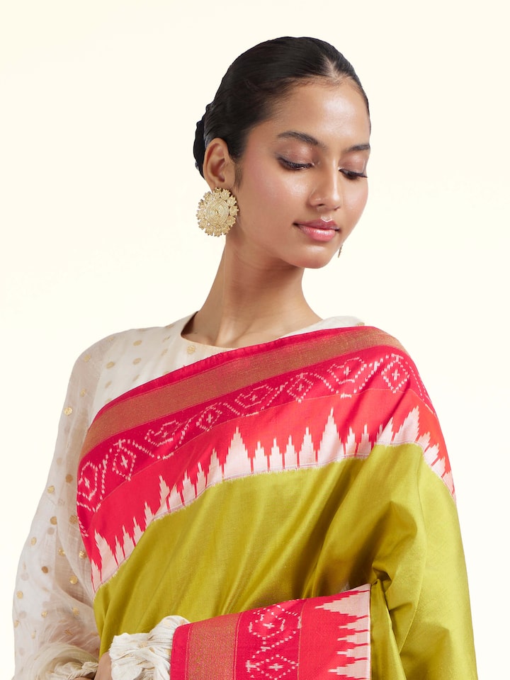 Angled view of mustard mulberry silk ikat saree highlighting ikat craftsmanship