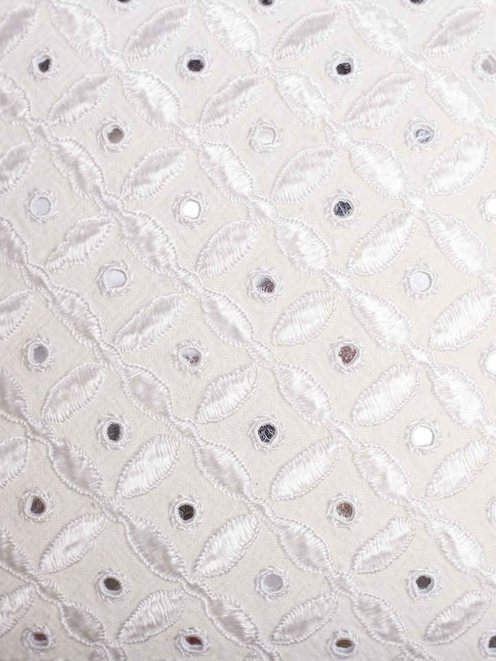 Close-up of allover Pakko hand embroidery on white cushion cover