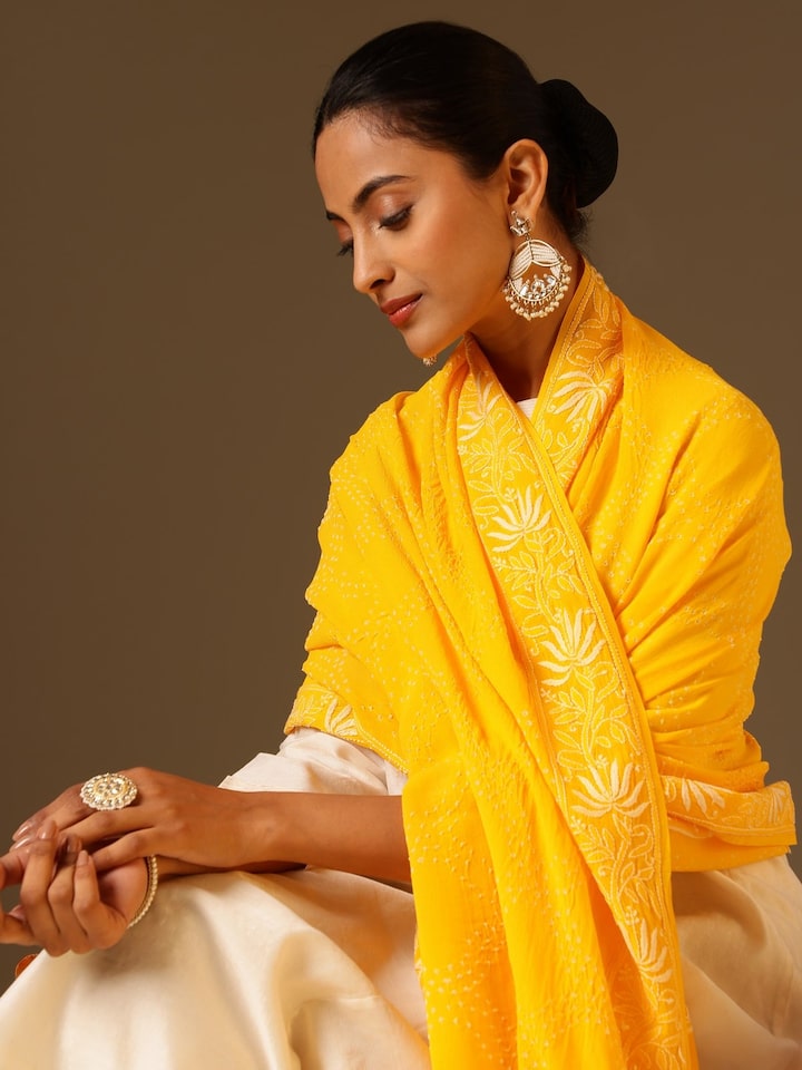 Angled view of yellow georgette bandhani tie and dye dupatta highlighting bandhani motifs