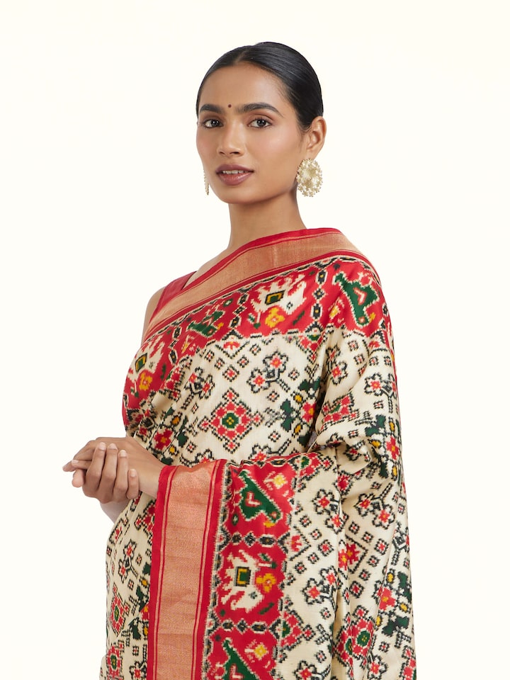 angled view of cream pochampally double ikat silk saree
