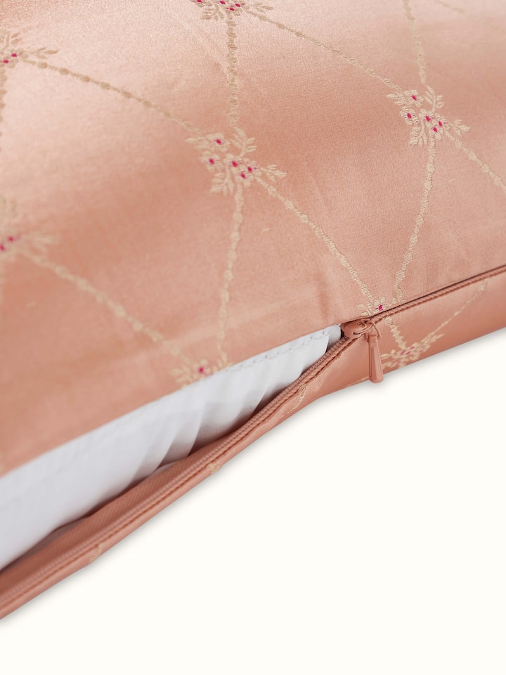 Angled view: Angled shot revealing golden jaal pattern on soft peach silk.