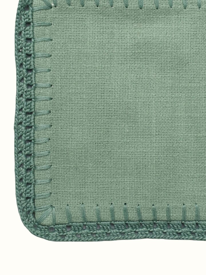 Detail view of Nityam Green Cotton Slub Crochet Coasters Set Of 6 highlighting the fabric texture and embroidery detail, from a different angle