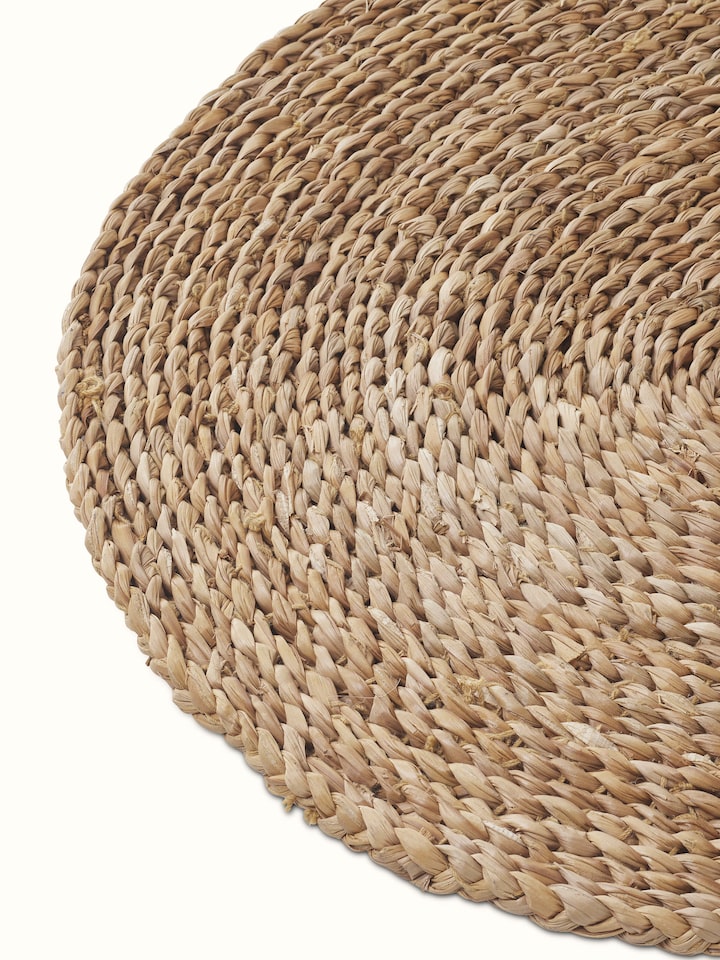 Vritti brown solid oval natural fibre trivets in a setting, demonstrating their practical use and aesthetic appeal.
