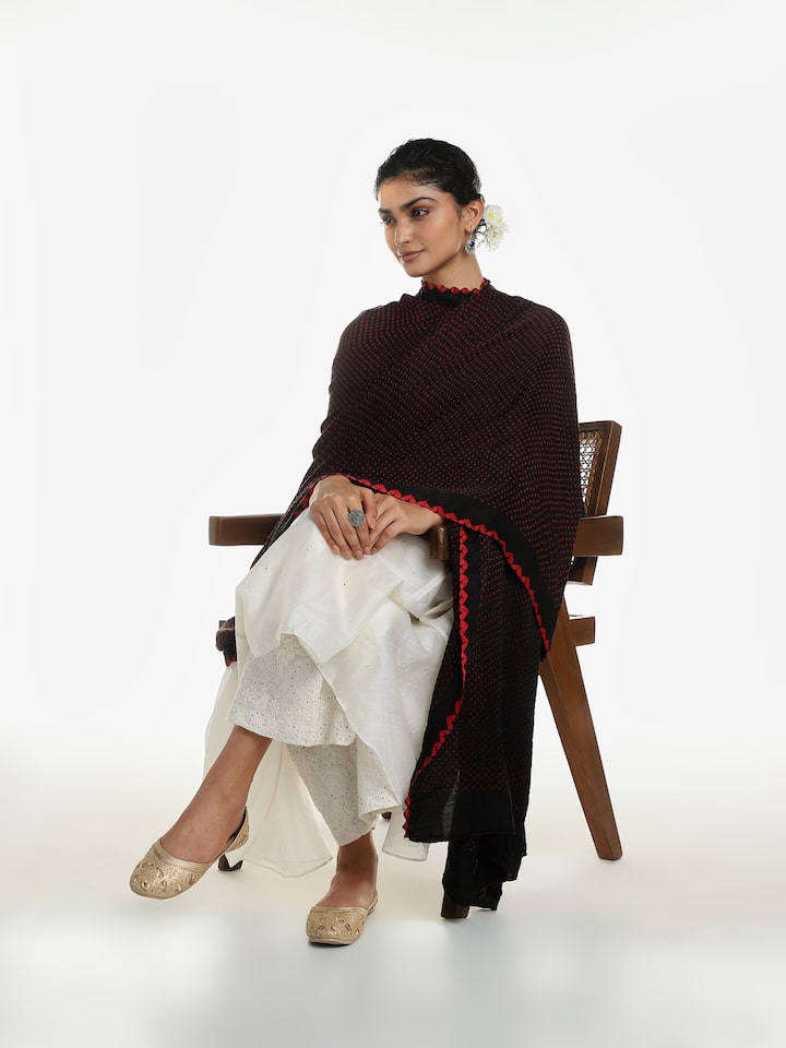 Side view of black Gajji silk Bandhani tie and dye dupatta with flowing drape